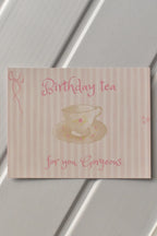 This image shows a beautiful, detailed view of the front of the Birthday Tea Postcard, highlighting the delicate pink striped design and the whimsical teacup illustration—a perfect warm invitation.