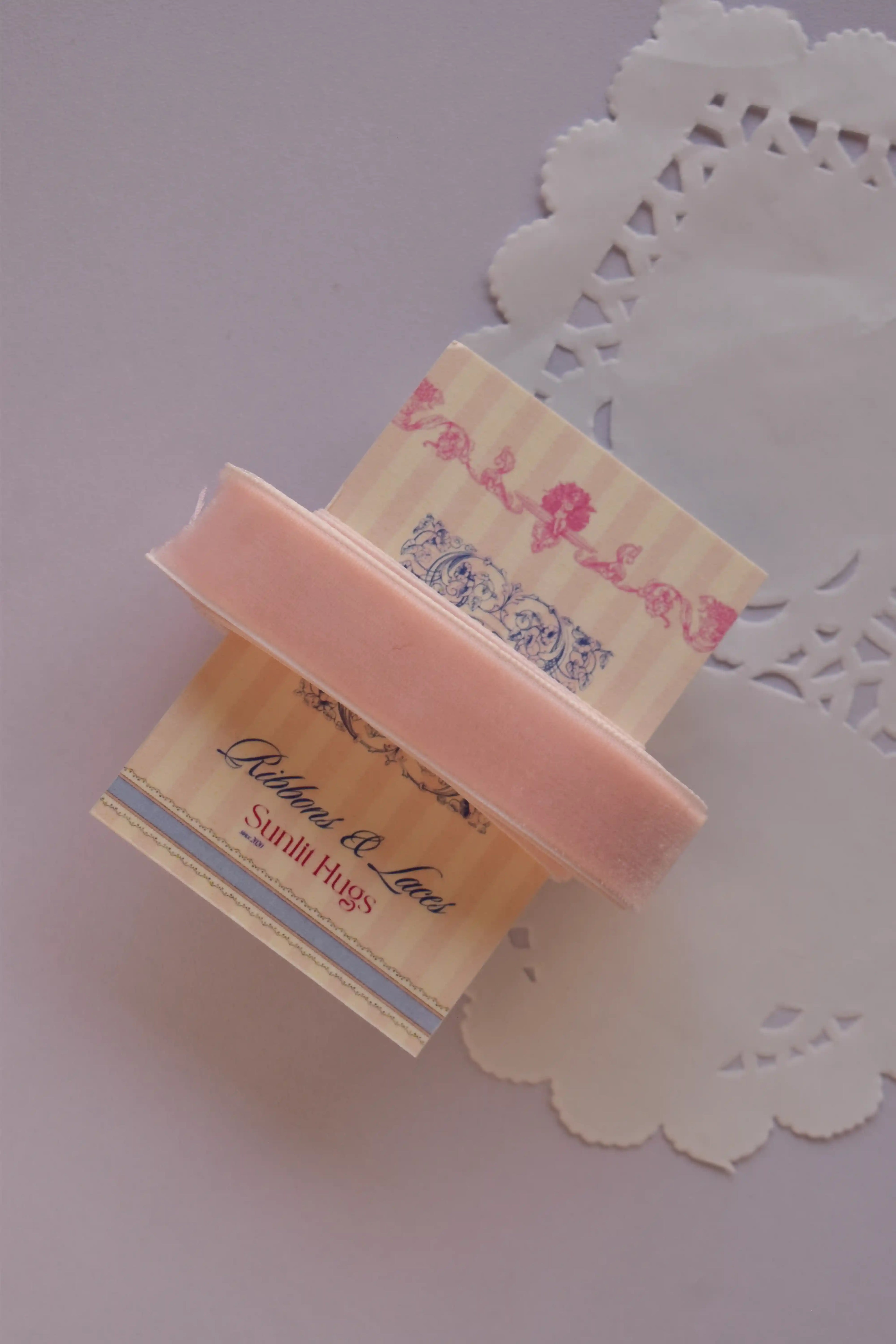 Soft pink velvet ribbon (15mm wide, 2 Metres) draped around a "Sunlit Hugs" card on a white lace doily.