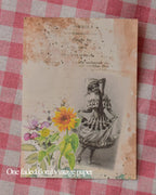 Single faded floral vintage paper featuring a woman in a historical dress and bright yellow sunflowers.