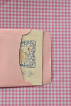 This view captures the beginning of the card's journey, showing the Grateful For You card, with its beautiful blue design, being placed into the pink envelope, ready to be sent as a warm gesture of thanks.