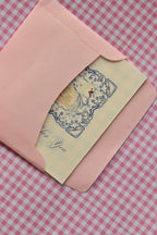 This image offers an edge-on view of the Grateful For You card nestled inside the pink envelope, highlighting the subtle beauty of the card's cream colour and blue lace design as it awaits sealing.