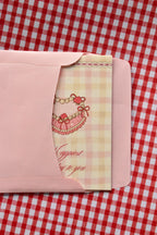 This view captures the Happiest Birthday to You card being gently placed into the pink envelope. It demonstrates the presentation, with the sweet pink heart-shaped cake illustration peeking out as it awaits its recipient.