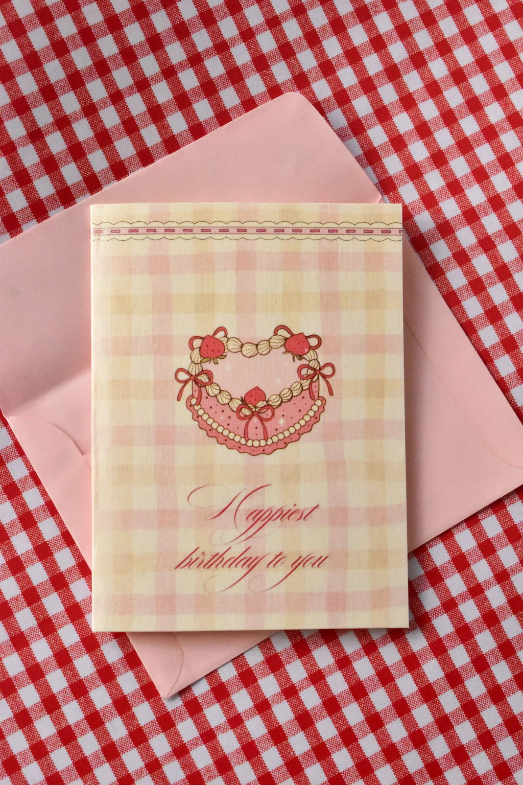This image shows the front of the 'Happiest Birthday to You' card, featuring the nostalgic strawberry heart cake design and pink and cream gingham pattern from the set.