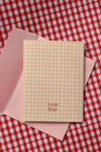 This image displays the back of the Happy Birthday Cutie card. The continuous pink and cream gingham design and the Sunlit Hugs logo are visible, reinforcing the charming, cohesive look.