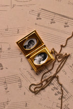 A detailed view of the open golden alloy locket, showcasing the quality of the two custom inserted black and white photographs, ready to preserve a precious moment.