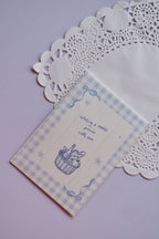 Front of the Mini Wishing Picnics Card featuring a blue gingham background and a picnic basket illustration.