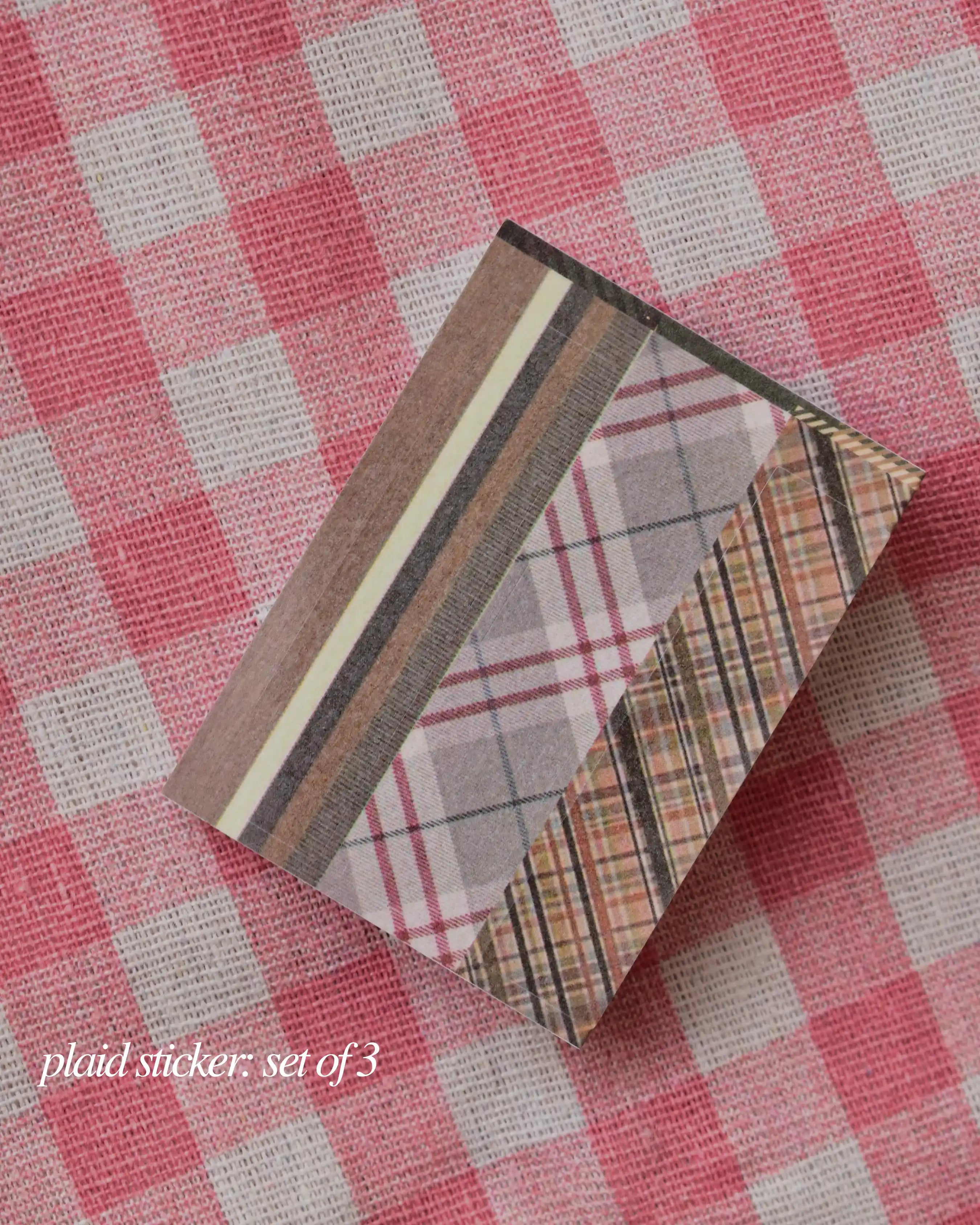 Stack of three plaid patterned stickers in brown, grey, and cream tones, ready for decorative use.