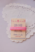Narrow pink and white gingham ribbon (2 Metres) wrapped around a "Sunlit Hugs" card, with a loose strand flowing below on a lace doily.