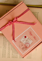 This image showcases the thoughtful gift packaging, confirming that the Classic Scarlet Letter arrives wrapped in a charming 'Happy Mail' box sealed with a red gingham ribbon bow.